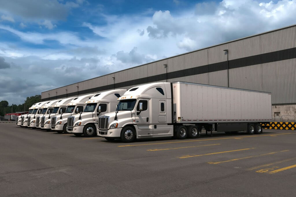 Semi trucks parked at a fleet yard for Form 2290 heavy vehicle tax compliance